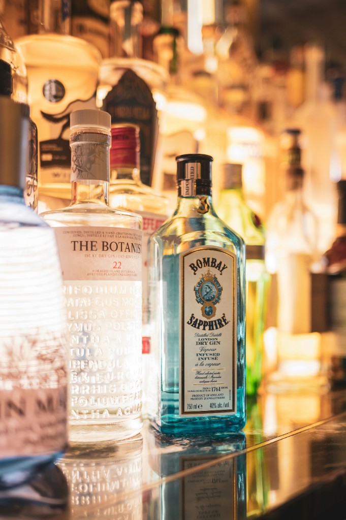 Backlit premium gin and spirits bottles on a bar shelf